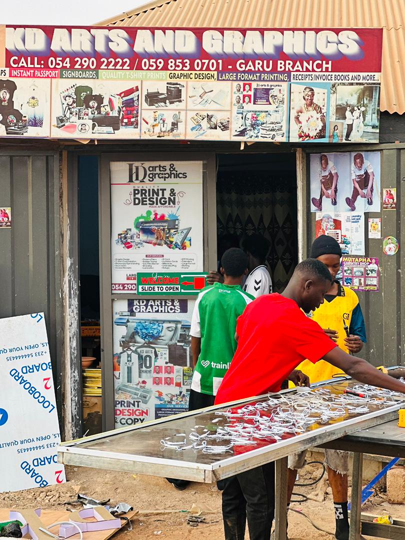 KD Arts and Graphics Garu storefront with signage and team at work outside