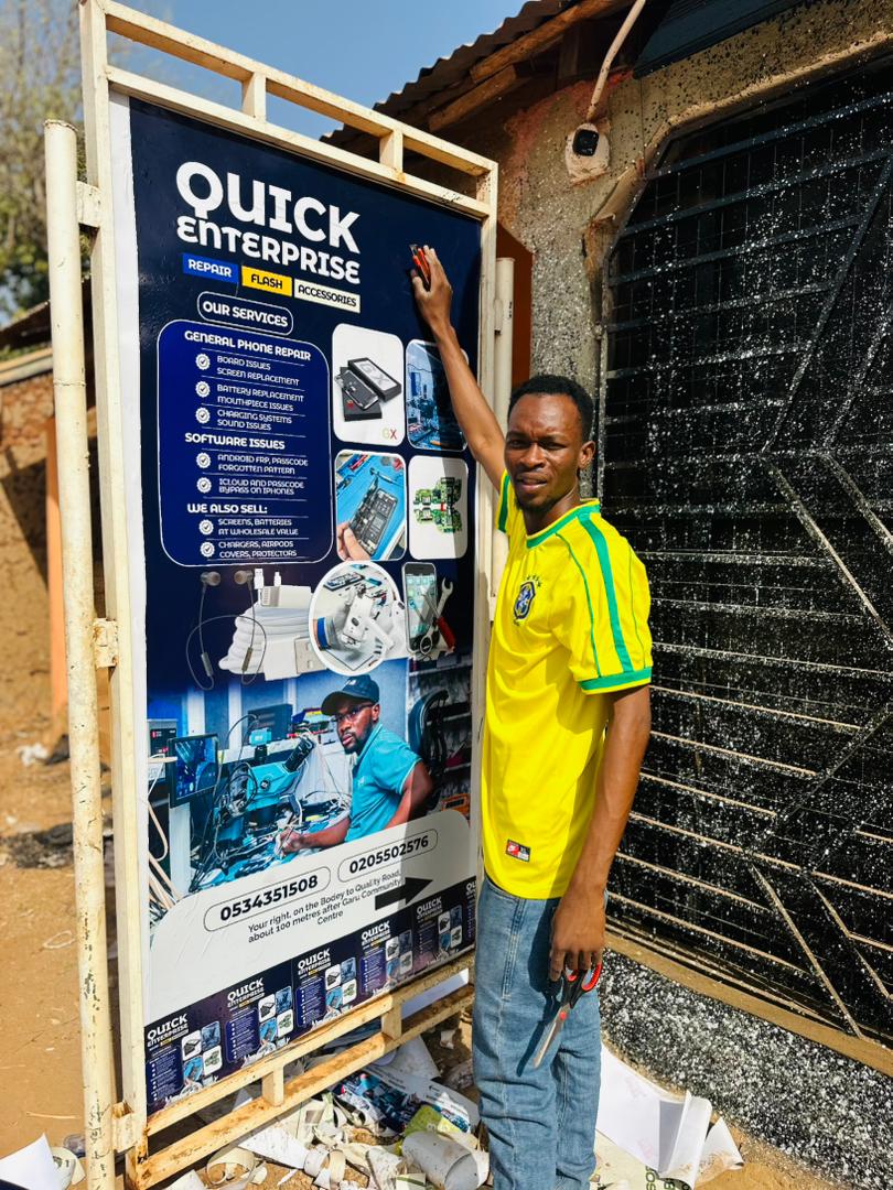 KD Arts team member proudly displaying a large signboard they produced