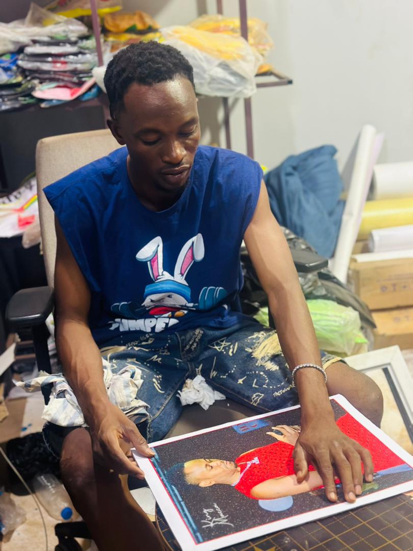 KD Arts team member reviewing a large printed photo in the studio workspace